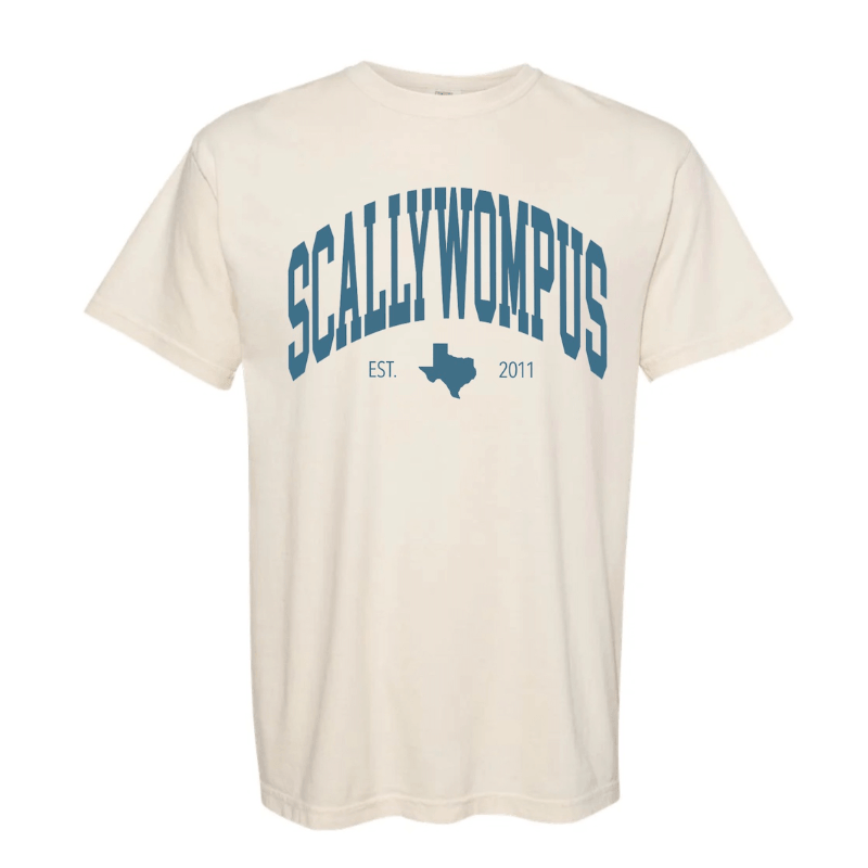 An ivory Comfort Colors t-shirt with "Scallywompus" printed across the chest in blue ink and in an arched collegiate style font. Underneath it an image of the state of Texas is printed along with "EST. 2011"